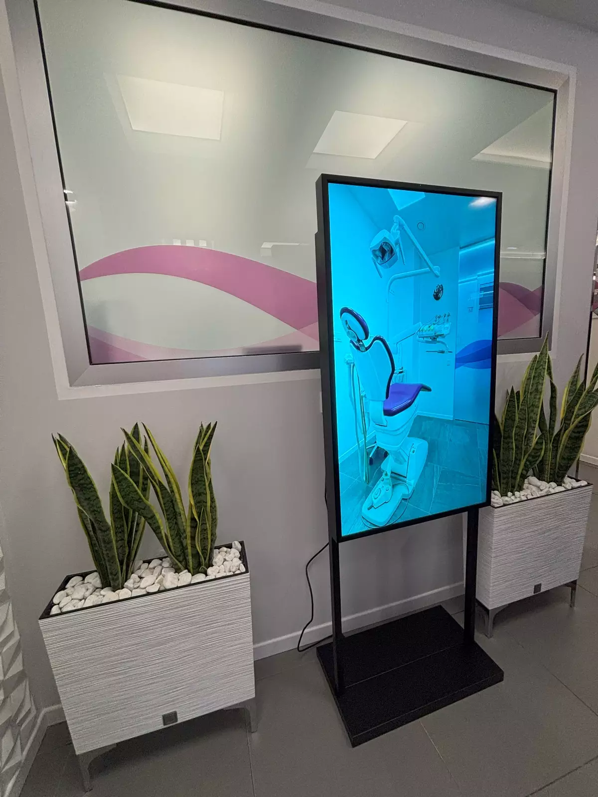 Pantalla grande donde se puede ver una fotografía de un sillón de la clínica